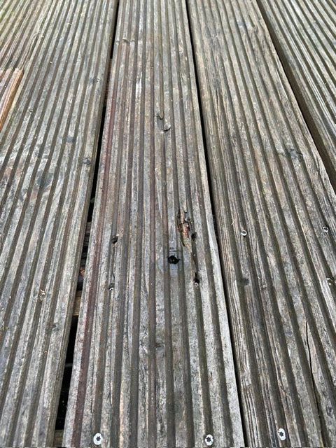 Verwittertes Terrassenholz mit einem ungleichem Fugenbild. 