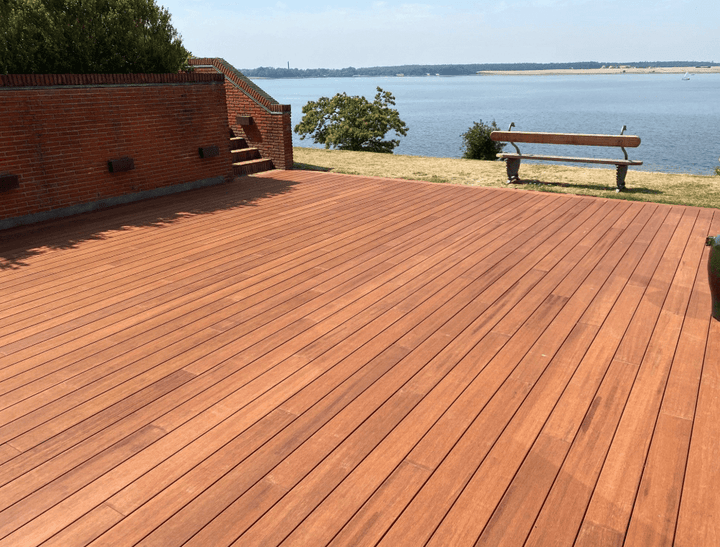 Detailaufnahme einer mehrstufigen Terrasse aus braunen Bambus Terrassendielen neben einem Pool. Die Dielen sind sauber verarbeitet und bilden mehrere Sitz- oder Trittstufen mit exakt ausgeführten Eckverbindungen. Das klare Design und die warme Holzfarbe verleihen dem Außenbereich eine moderne und hochwertige Optik.