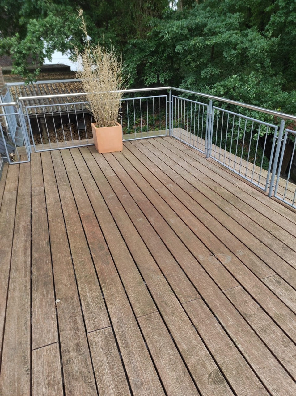 Ein verwitterter Balkonbelag aus Bambus vor der Unterhaltspflege.