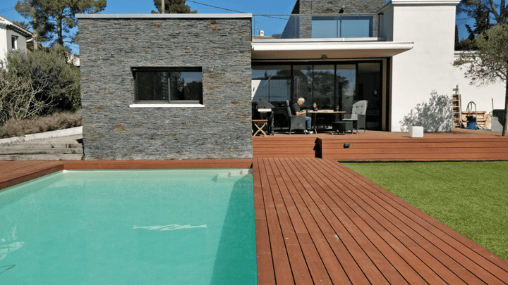Moderne Poolterrasse mit langlebigen aMBOOO Bambus Terrassendielen in Holzoptik, gemütlicher Loungeecke und großzügigem Außenbereich für entspannte Sommertage