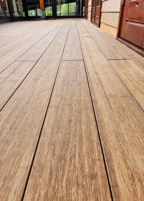 Ein aMbooo Bambus Terrassenbelag mit einer Microfuge verlegt auf einem Balkon - Nahaufnahme- vorgeölt in der Farbe Sand.