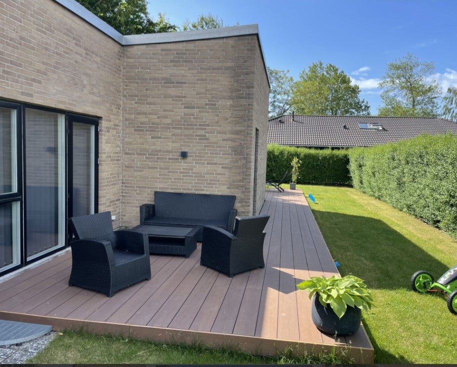 Terrasse mit Holguin Bambus-Terrassendielen in edler Holzoptik, gemütlicher Sitzecke an einem modernen Klinkerhaus.