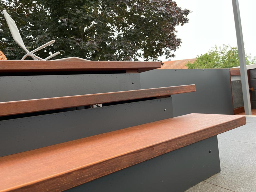 Nahaufnahme einer modernen Außentreppe mit braunen Bambus-Trittstufen und anthrazitfarbenen Setzstufen auf einer Terrasse.